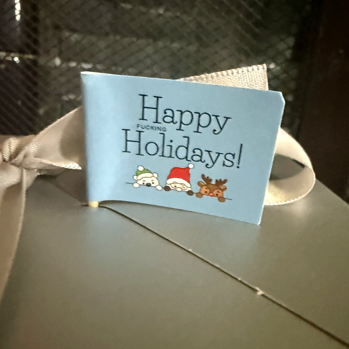 Happy Fucking Holidays flag on a wrapped gift