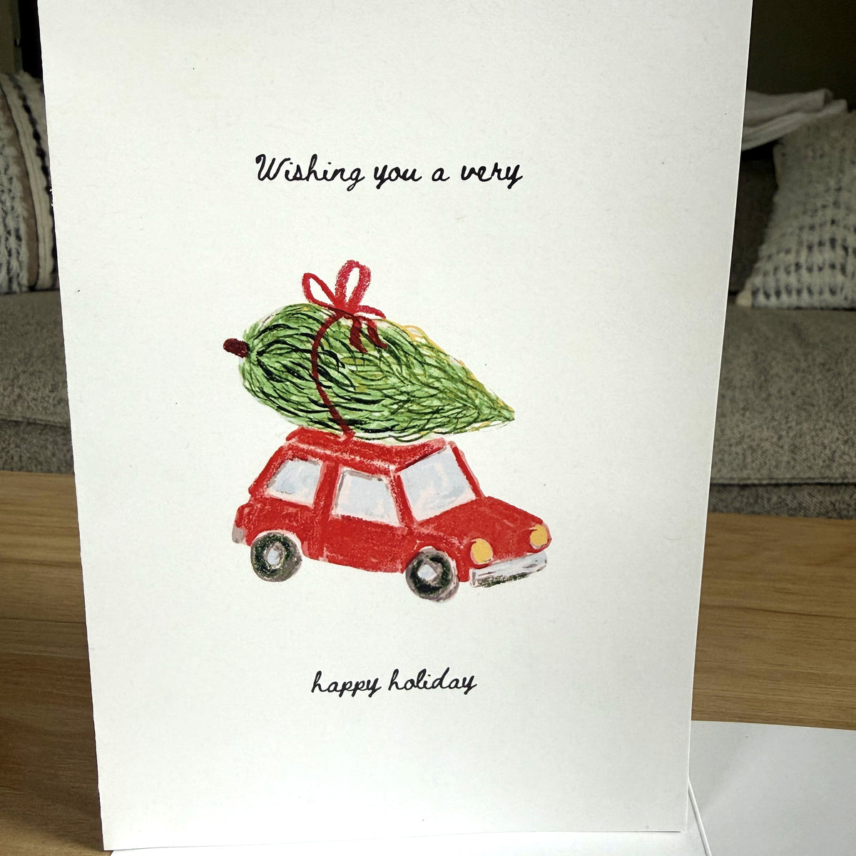 Very Happy Holiday card front with red car and Christmas tree