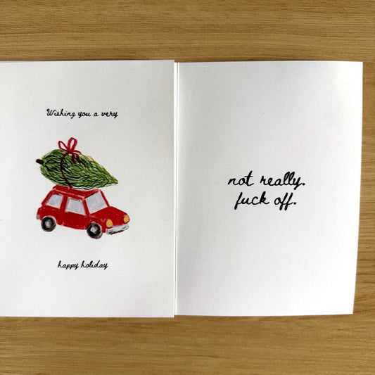 Very Happy Holiday card open flat on a wood table
